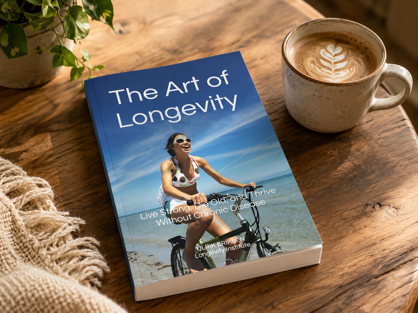 The Art of Longevity by Ulrik Eriksen, resting on a wooden table beside a cup of coffee